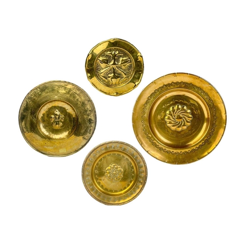 128 - A large brass circular alms dish. With central gadrooned decoration, diameter 41.5cm together with t... 