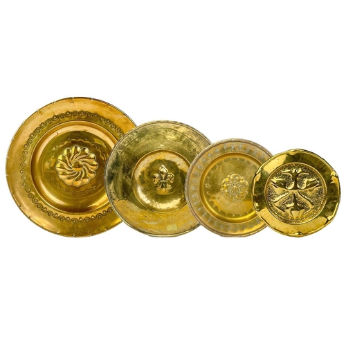 128 - A large brass circular alms dish. With central gadrooned decoration, diameter 41.5cm together with t... 