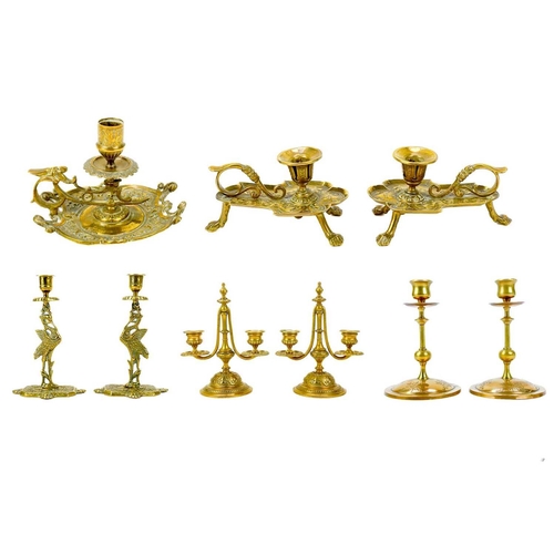 153 - A pair of Victorian brass chambersticks. Ornately decorated with lion paw feet, together with three ... 