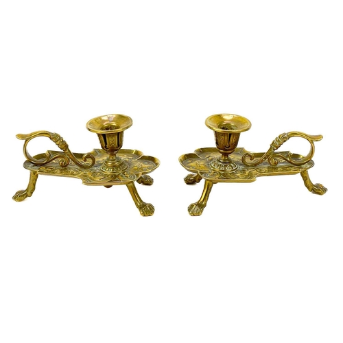 153 - A pair of Victorian brass chambersticks. Ornately decorated with lion paw feet, together with three ... 