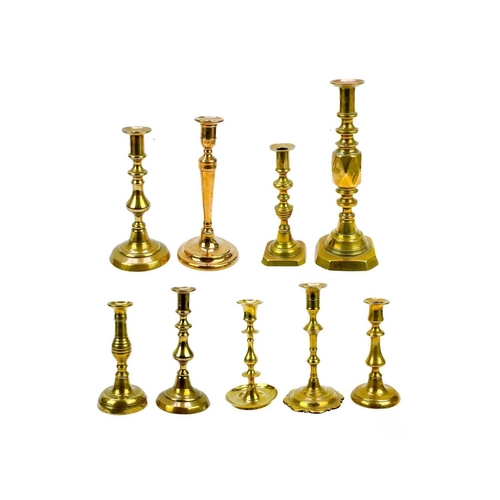 162 - An 18th century brass candlestick with petal base. Height 20cm together with eight other single cand... 