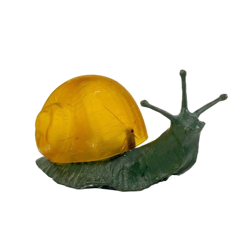 169 - A novelty table lamp in the form of a snail. The simulated bronze body surmounted by an amber glass ... 