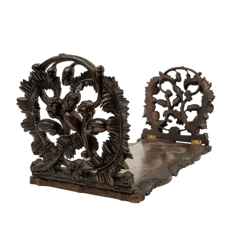 174 - A late 19th century Black Forest book slide. The pierced carved ends decorated with fern leaves and ... 