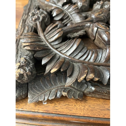 174 - A late 19th century Black Forest book slide. The pierced carved ends decorated with fern leaves and ... 