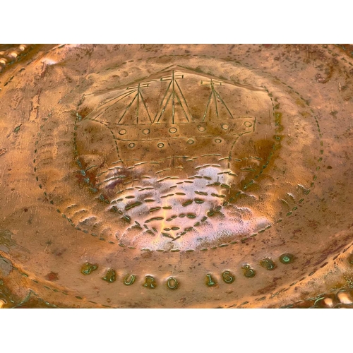 175 - A Cornish Arts and Crafts circular copper tray. By the Eustace brothers of Hayle, the centre decorat... 