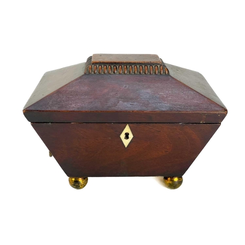 180 - A George III mahogany sarcophagus tea caddy. With twin brass cornicopia handles on brass ball feet. ... 
