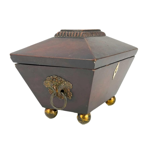 180 - A George III mahogany sarcophagus tea caddy. With twin brass cornicopia handles on brass ball feet. ... 