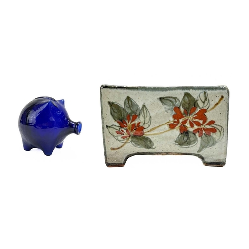 395 - A Bristol blue pig money box. Height 7cm together with a studio pottery flower brick. (2)