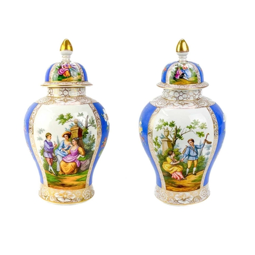 483 - A pair of German porcelain baluster vases and covers. Decorated on blue ground with panels of courti... 