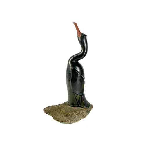 486 - Humfrey Wakefield - A pottery cormorant on stone stand. With HW seal mark. Height 39cm. Together wit... 