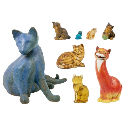489 - A glazed blue ceramic cat figurine. Height 29cm. Together with seven other various feline figurines.