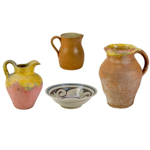 516 - A large pottery jug. Height 32cm together with two other pottery jugs and a large studio pottery dis... 