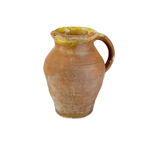 516 - A large pottery jug. Height 32cm together with two other pottery jugs and a large studio pottery dis... 