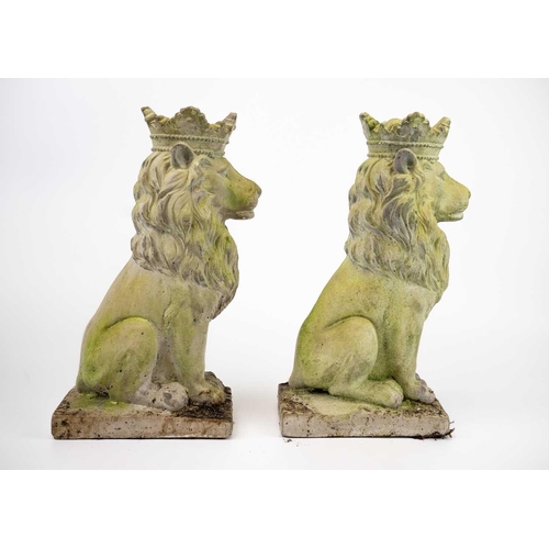 524 - A pair of reconstituted stone sculptures of seated lions wearing crowns. Height 35cm.