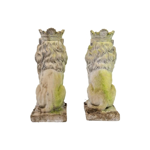 524 - A pair of reconstituted stone sculptures of seated lions wearing crowns. Height 35cm.