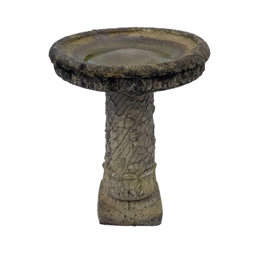 530 - A cast reconstituted stone birdbath. Raised on fruiting vine pedestal. Height 70cm, diameter 56cm.