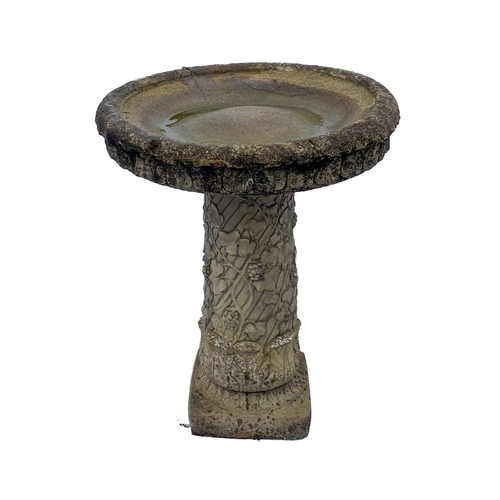 530 - A cast reconstituted stone birdbath. Raised on fruiting vine pedestal. Height 70cm, diameter 56cm.