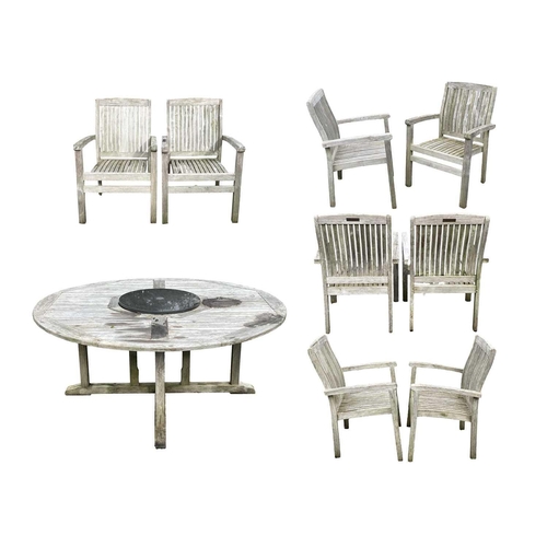 533 - A large circular weathered teak garden table. With polished granite Lazy Susan, diameter of top 180c... 