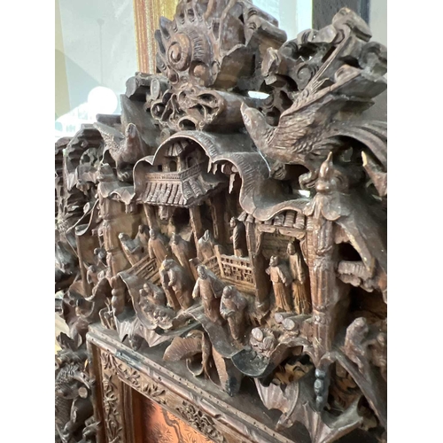 124 - A Chinese carved wood photo frame, early 20th century. Carved with dragons, birds, animals, pagodas ... 