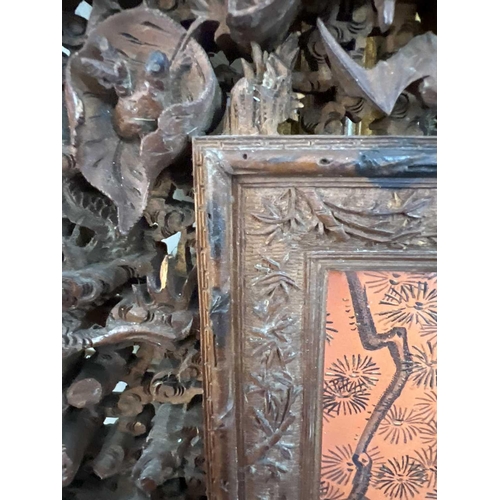 124 - A Chinese carved wood photo frame, early 20th century. Carved with dragons, birds, animals, pagodas ... 