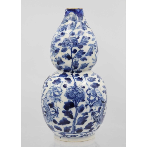 219 - A Chinese blue and white porcelain double gourd vase, circa 1900. Decorated with dragons and floweri... 