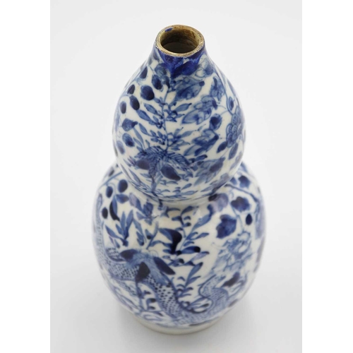 219 - A Chinese blue and white porcelain double gourd vase, circa 1900. Decorated with dragons and floweri... 