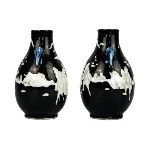 243 - A pair of Chinese noire twin-handled ovoid vases, circa 1900. With figures in a landscape, some on h... 