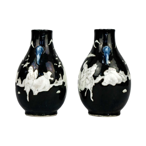 243 - A pair of Chinese noire twin-handled ovoid vases, circa 1900. With figures in a landscape, some on h... 