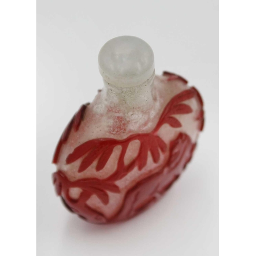 244 - A Chinese red overlay glass snuff bottle. With hardstone stopper, the body depicting horses below wi... 