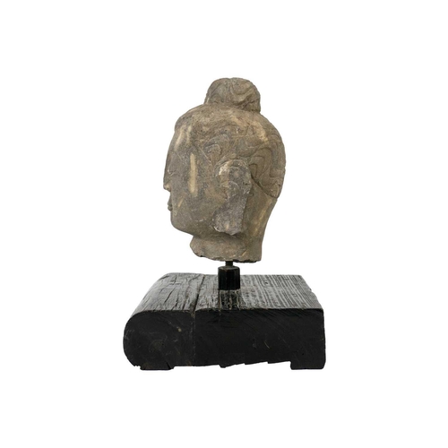 293 - A carved stone Buddha head. Mounted on a wooden plinth base, height of head 20cm, width 12.5cm, dept... 