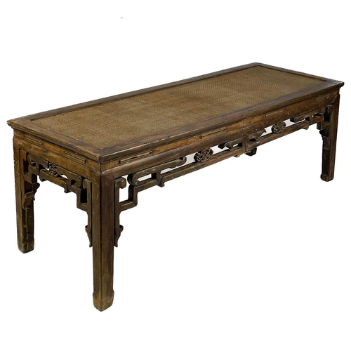 323 - A Chinese hardwood Kang table, early 20th century. The rattan covered top, above a pierced frieze on... 