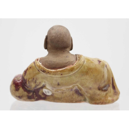 352 - A Chinese pottery model of Buddha, 18th/19th century. The smiling Buddha in a large robe and reclini... 