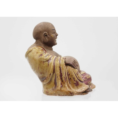 352 - A Chinese pottery model of Buddha, 18th/19th century. The smiling Buddha in a large robe and reclini... 