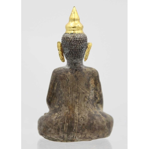 362 - A Chinese silver and wood Buddha, Qing Dynasty, 18th/19th century. In seated pose with gold ears, he... 