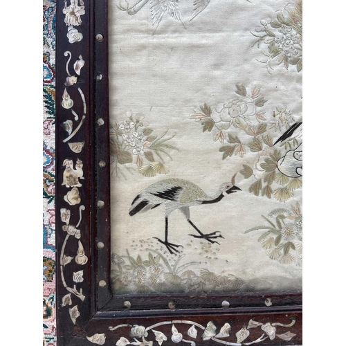 40 - A Chinese silk embroidered panel, circa 1900. Decorated with peacocks, trees and birds, with a card ... 