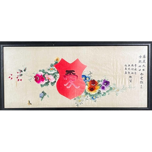 45 - A Chinese silk embroidered rectangular panel. The central shield flanked by colourful floral sprays ... 