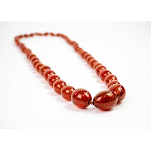 613 - An amber style graduated oval bead necklace. Length 47cm. 97 grams.