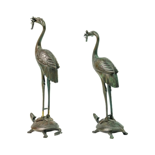 67 - A pair of Japanese bronze figures of storks, Meiji period. Each perched on the back of stylised turt... 