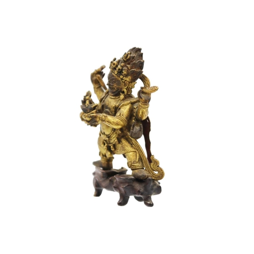 81 - A Sino-Tibetan gilt bronze figure of Mahakala, 18th/19th century. With six arms, his flame like tuft... 