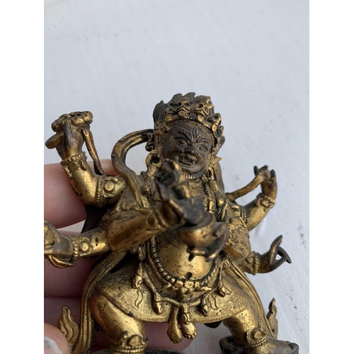 81 - A Sino-Tibetan gilt bronze figure of Mahakala, 18th/19th century. With six arms, his flame like tuft... 