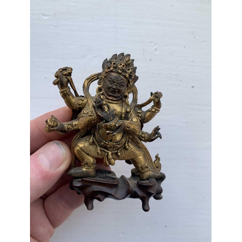 81 - A Sino-Tibetan gilt bronze figure of Mahakala, 18th/19th century. With six arms, his flame like tuft... 