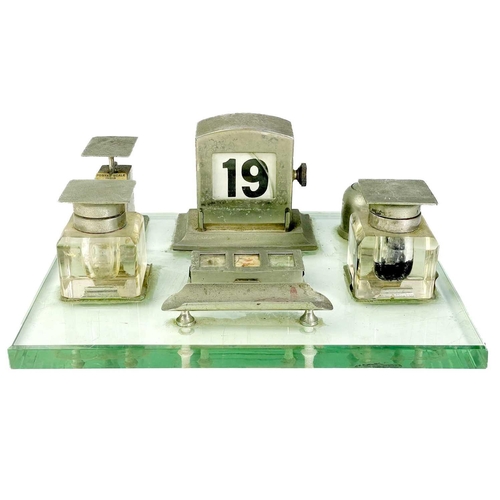 108 - An unusual and comprehensive Art Deco chrome desk set on a glass base. Fitted with twin ink bottles,... 