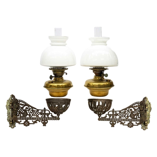 166 - A pair of late Victorian Aesthetic movement cast iron and brass oil wall lights. With hinged brass m... 