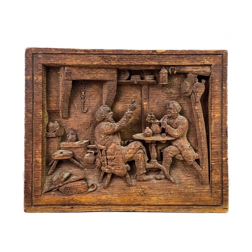 177 - A carved oak plaque. Depicting two topers in a rustic tavern, initial JMR, 20.5X26cm, a label states... 