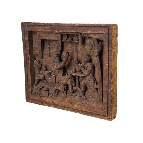 177 - A carved oak plaque. Depicting two topers in a rustic tavern, initial JMR, 20.5X26cm, a label states... 