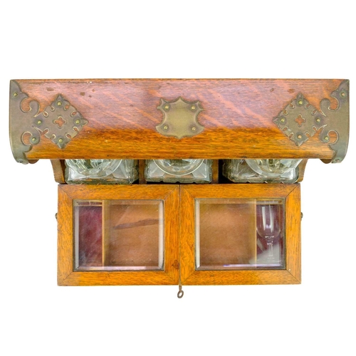 180 - A late Victorian oak tantalus and cigar cabinet. Fitted three cut glass decanters and stoppers, with... 