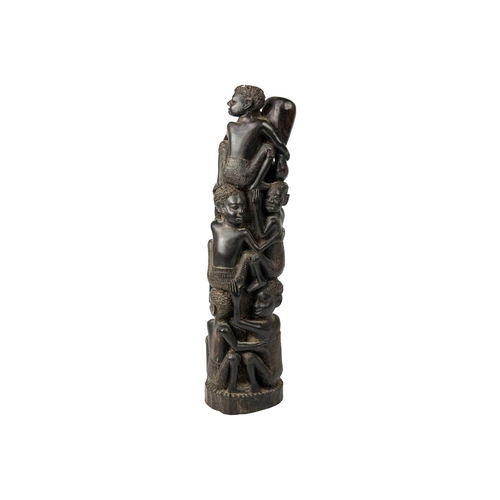 189 - An African hardwood carving group. Decorated with climbing figures, height 40cm. Maurice Jenkins (19... 