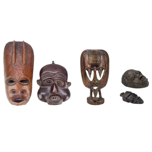 194 - An African carved wood carved mask. Probably Cameroon, with bone teeth, inflated cheeks and remnants... 