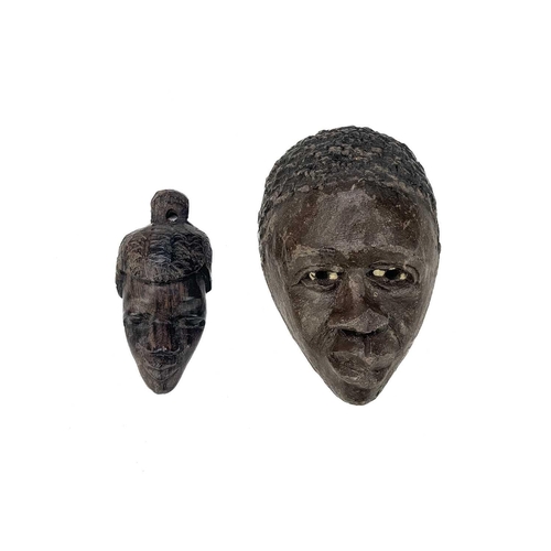 194 - An African carved wood carved mask. Probably Cameroon, with bone teeth, inflated cheeks and remnants... 