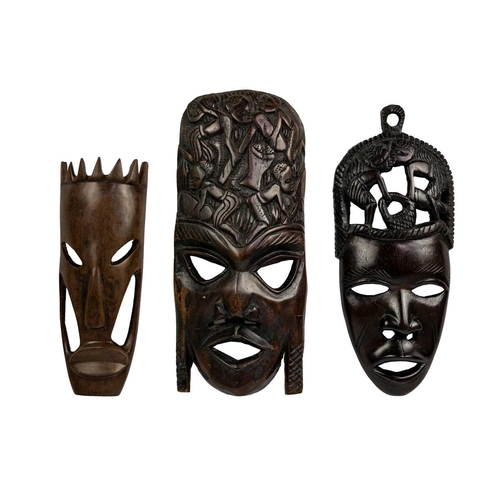 198 - An African tribal carved mask. Decorated in low-relief with figures, height 40cm together with two o... 